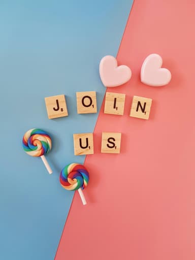 Colorfull image of the text Join Us written with scrabble letters, some candy and hearts